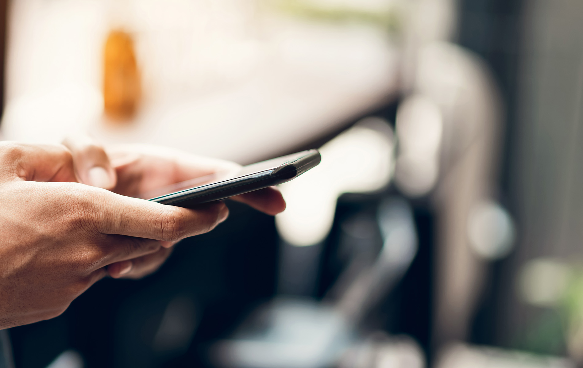 A person holding a smartphone, likely engaged in texting or browsing.